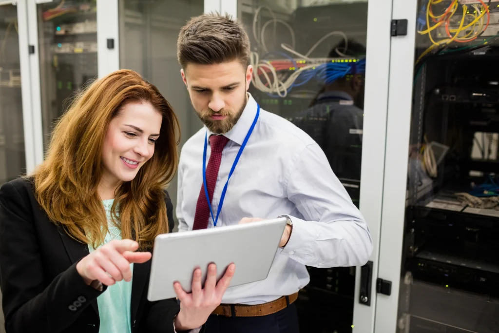 Technicians using digital tablet while analyzing server Helpdesk support from Tbourke Solutions
